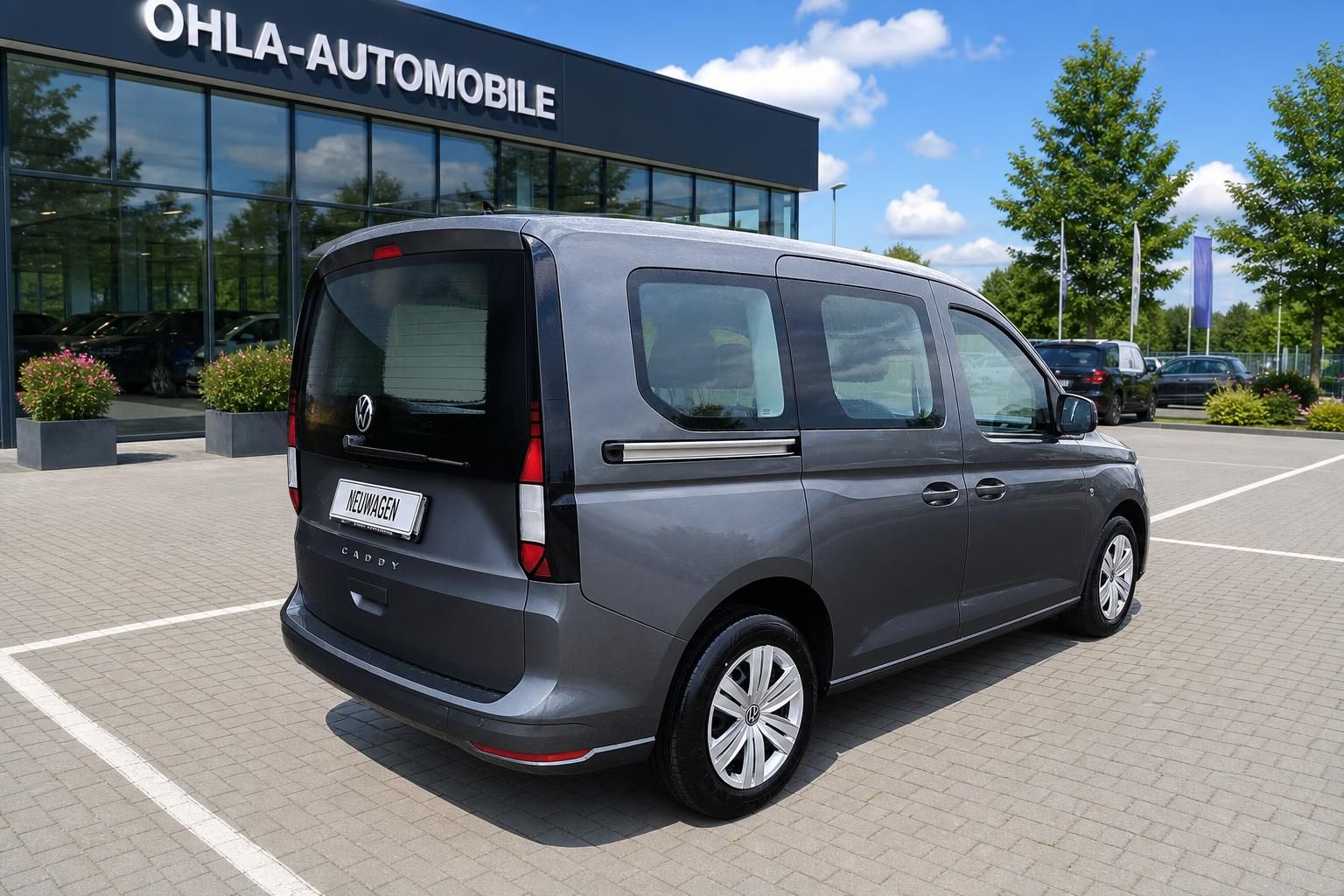 VW Caddy grau Heck- und Seitenansicht auf Hof des Autohauses