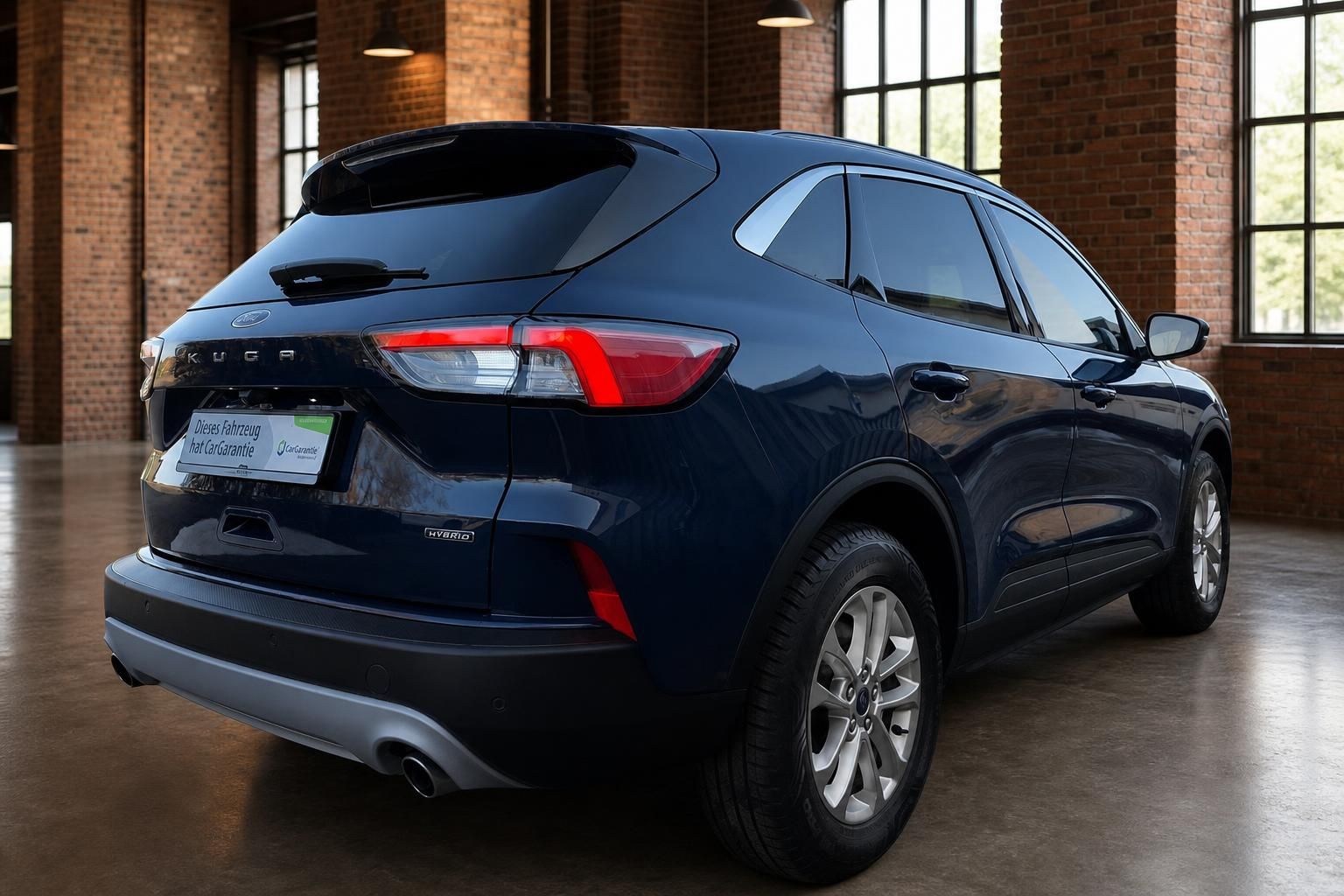 Ford Kuga Hybrid dunkelblau, Seiten-Heckansicht in Halle