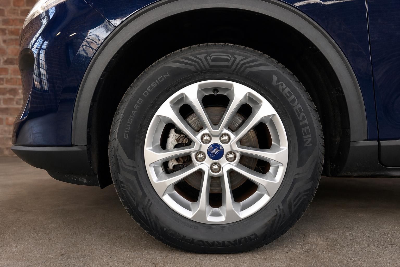 Ford Kuga blau, Nahaufnahme Felge und Reifen mit Ford-Logo