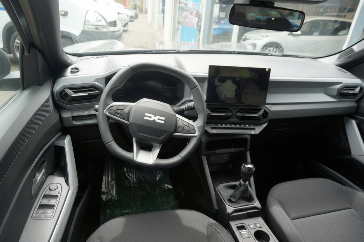 Dacia Innenraum mit Lenkrad, Infotainment-Bildschirm und Schaltgetriebe in modernem Design