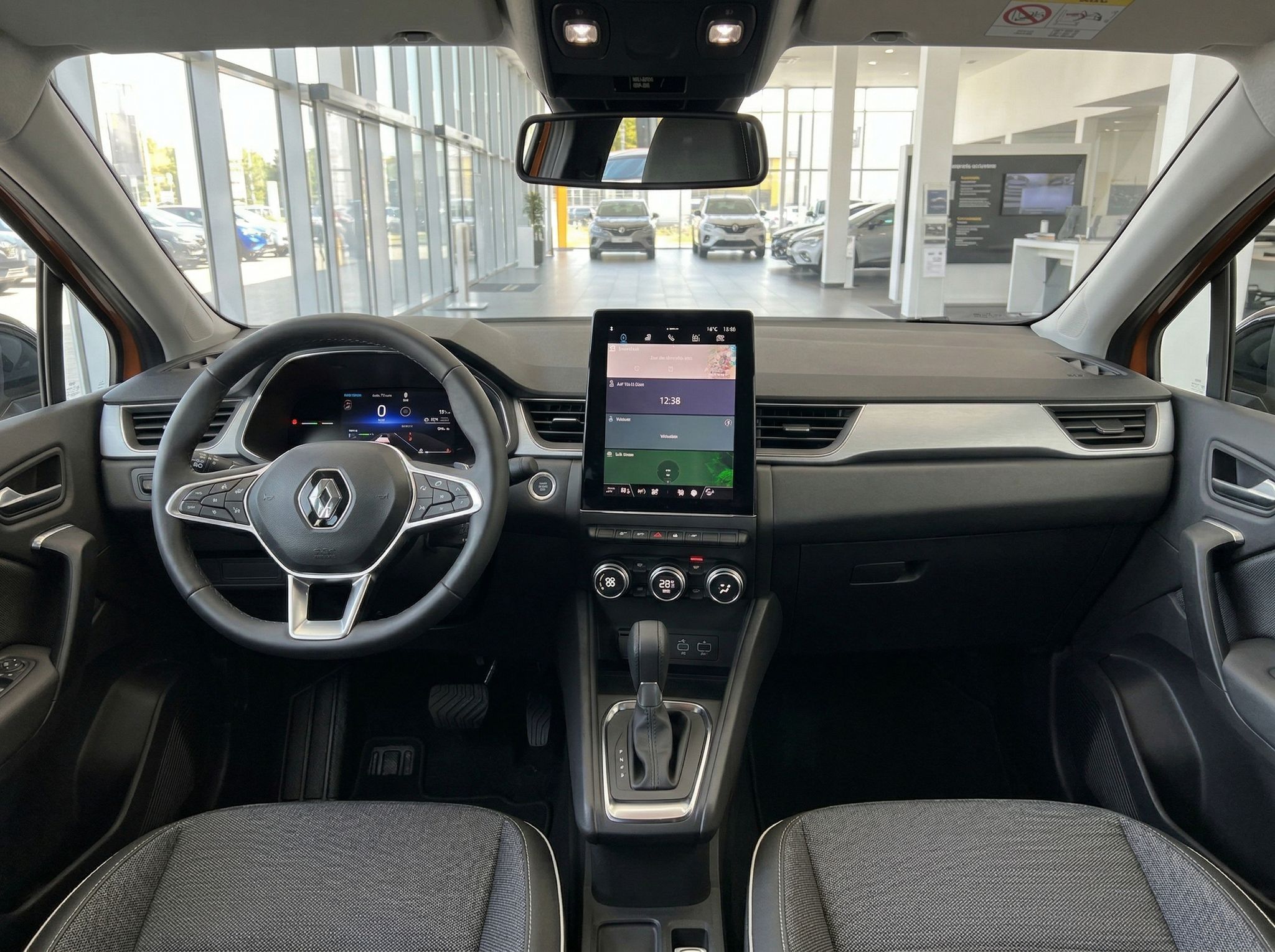 Renault Innenraum mit modernem Cockpit, Touchscreen-Display und Panorama-Schiebedach im Autohaus