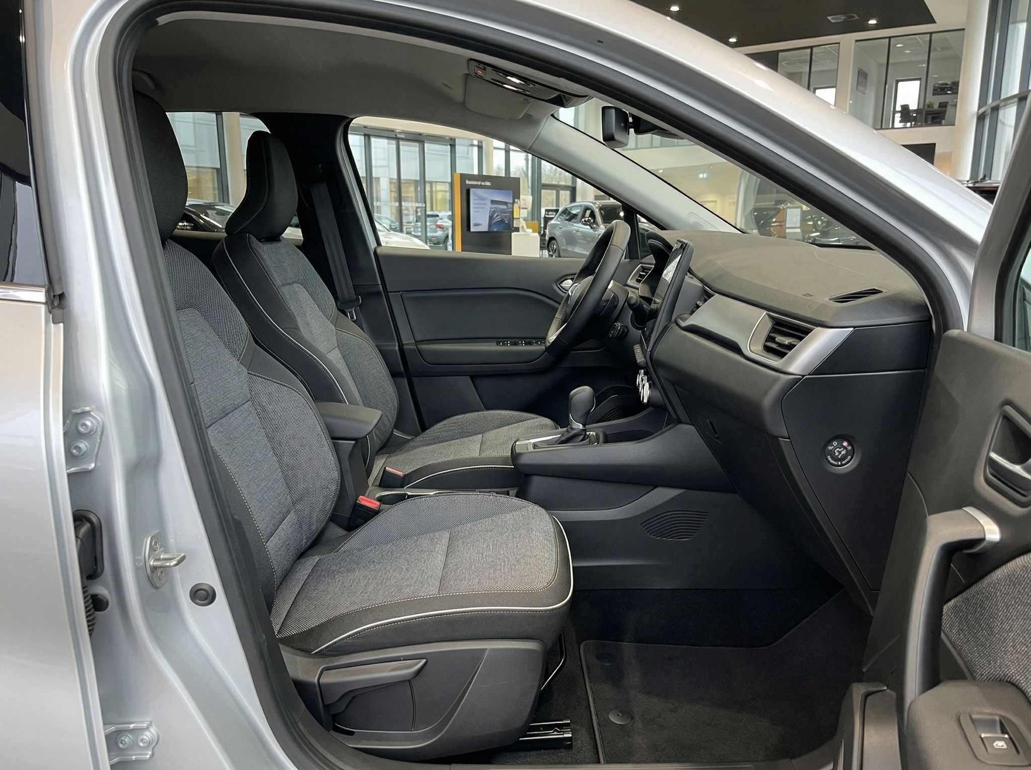 Renault Beifahrersitz und Armaturenbrett in grauer Stoff-Ausstattung mit offener Fahrzeugtür