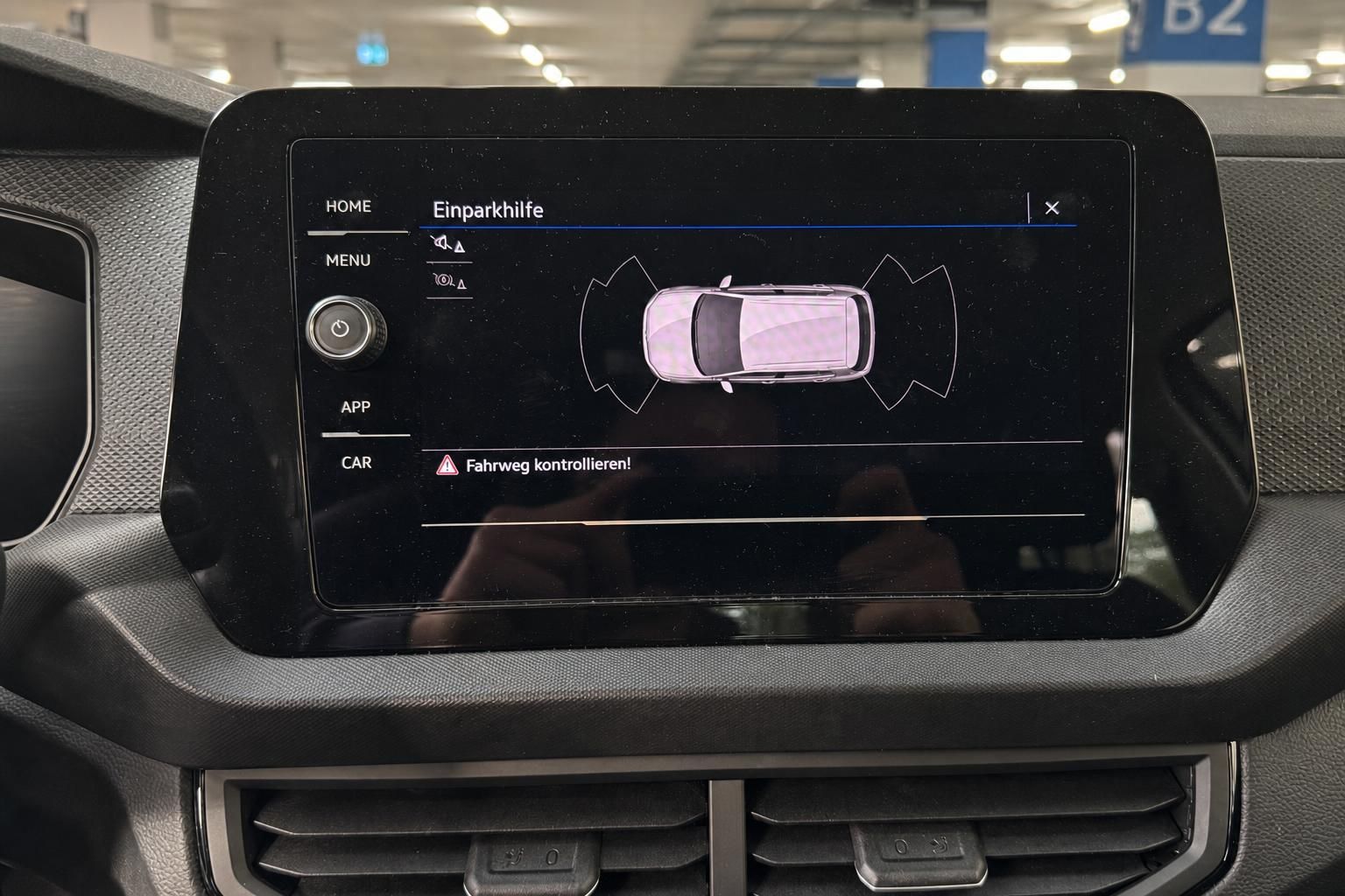 VW Infotainment-Display mit Einparkhilfe-Anzeige und Parkassistent im Fahrzeuginnenraum