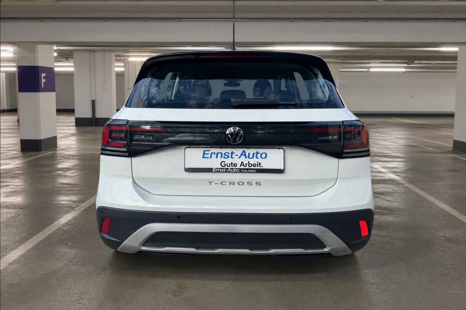 VW T-Cross weiss Heckansicht im Parkhaus mit Händlerschild Ernst-Auto