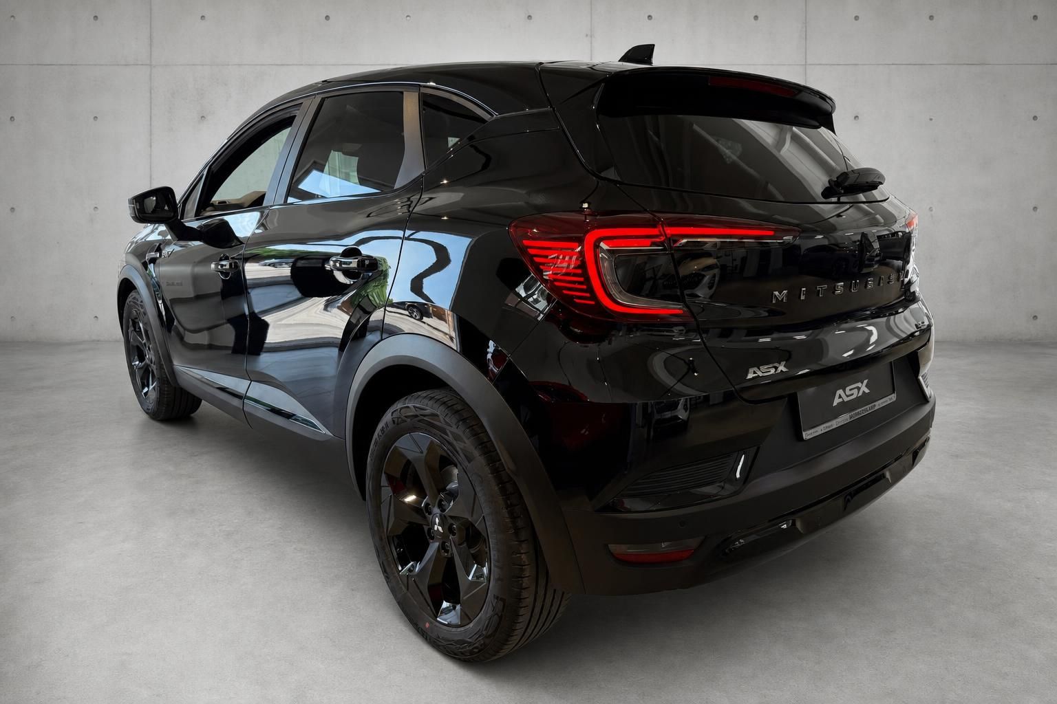 Mitsubishi ASX schwarz, Heckansicht seitlich mit Alufelgen im Studio