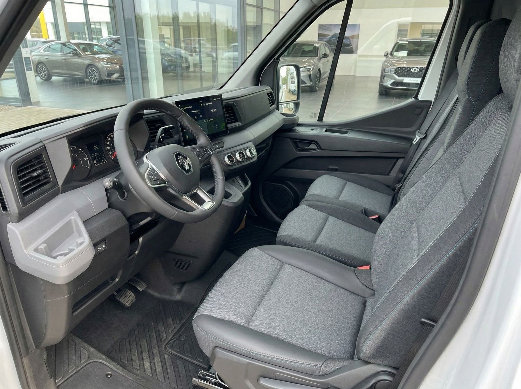 Renault Master Innenraum - Fahrerkabine mit Lenkrad, Touchscreen und grauen Stoffsitzen