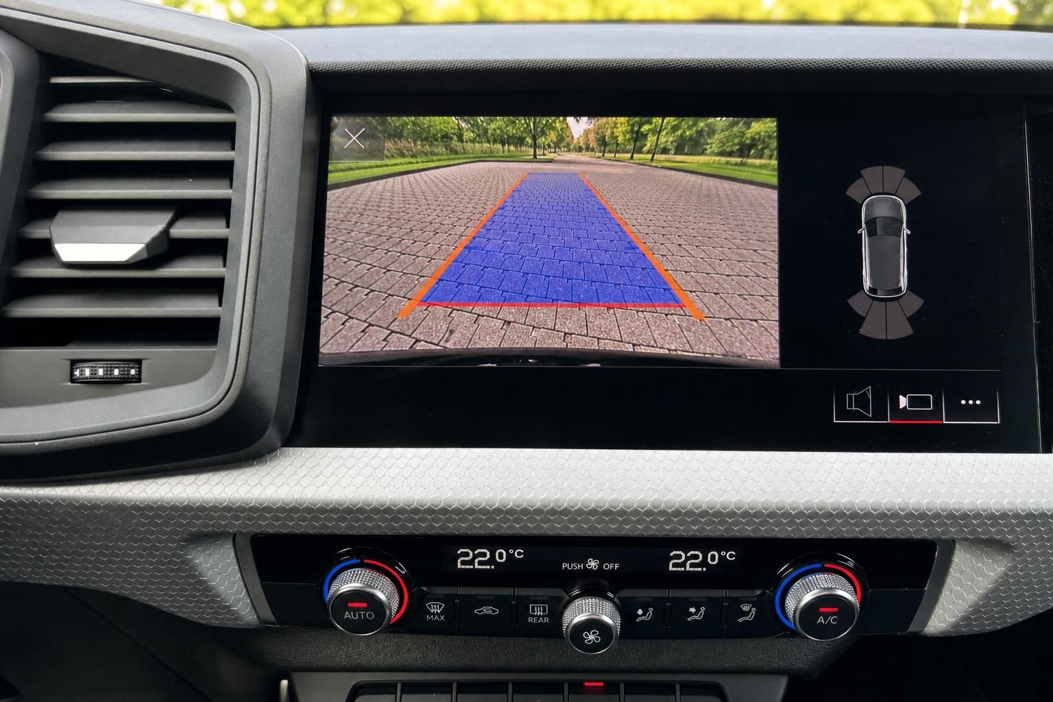 Rückfahrkamera-Display mit blauer Markierung und Einparkhilfe im Auto