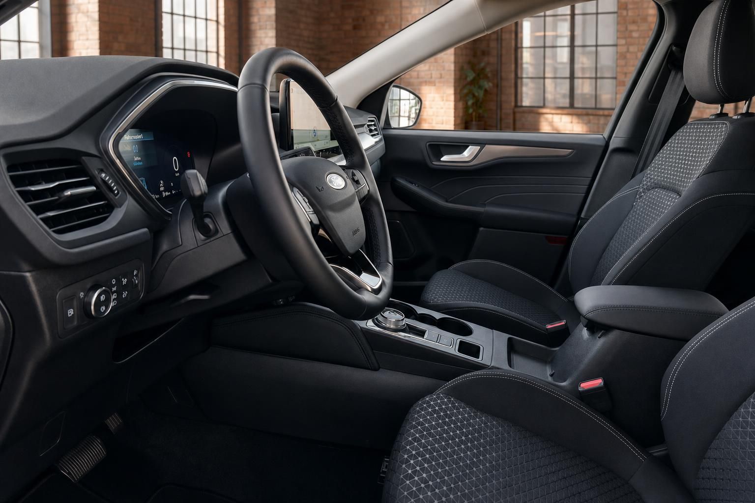 Ford Innenraum mit Lenkrad, Digitalcockpit und Sportsitzen im Vordergrund
