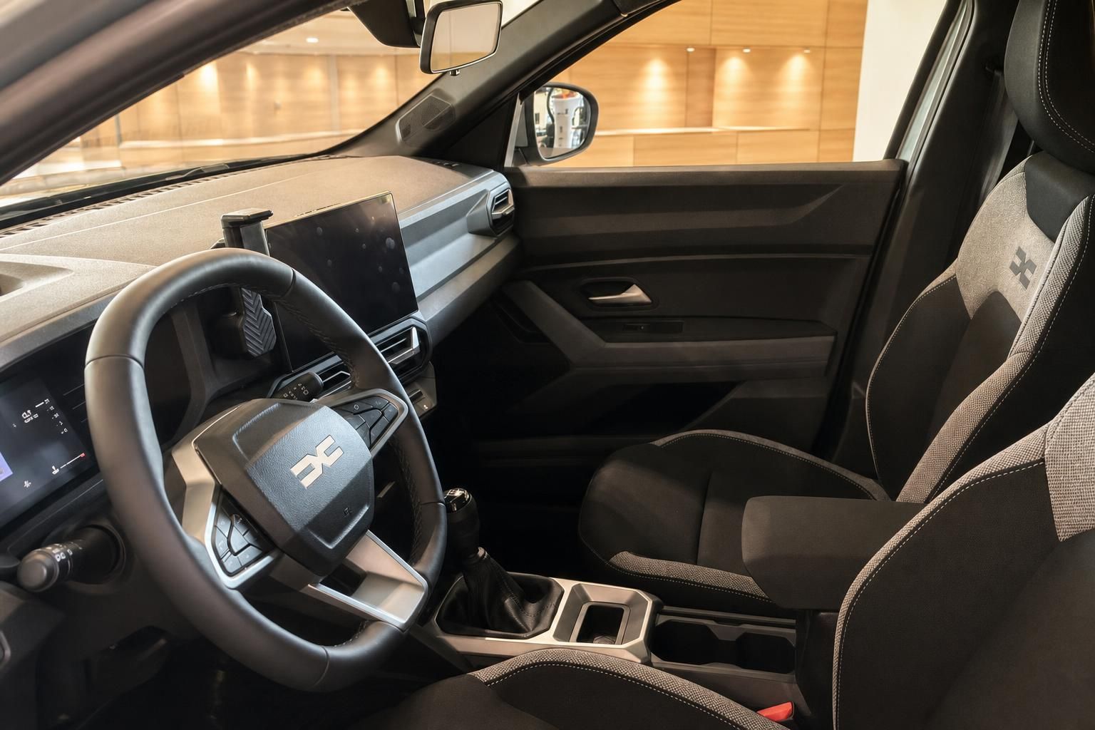 Dacia Innenraum Fahrersitz mit Lenkrad, Mittelkonsole und Beifahrersitz