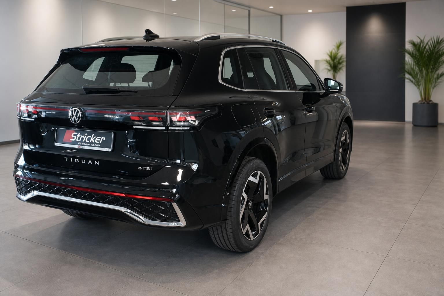 VW Tiguan eTSI schwarz Heckansicht im Autohaus Showroom