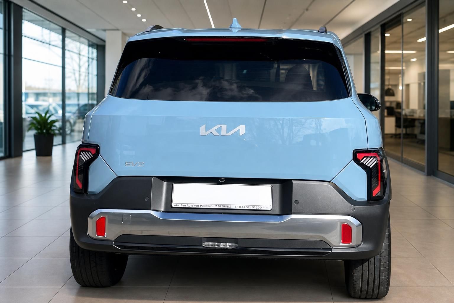 Kia EV3 Heckansicht in Hellblau mit LED-Rückleuchten im Showroom