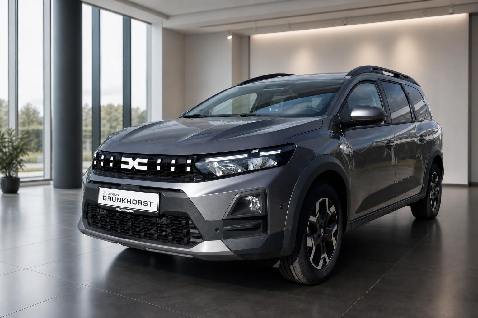 Dacia SUV grau Schrägansicht vorne links im modernen Autohaus Showroom
