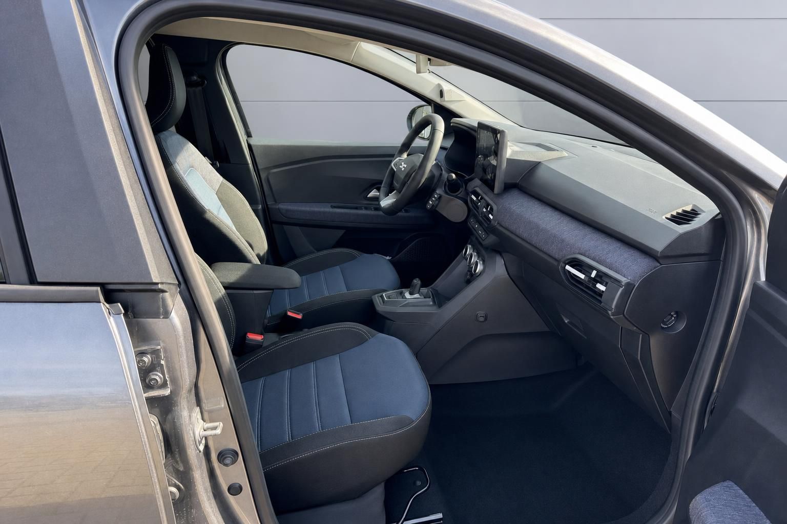 Innenraum eines modernen Fahrzeugs mit dunklen Sitzen und Mittelkonsole