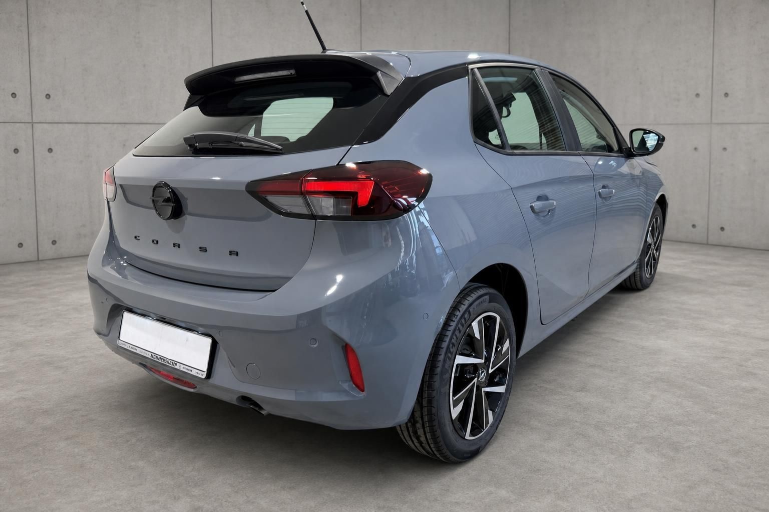 Opel Corsa grau, Heckansicht mit Kennzeichenhalter und Leichtmetallfelgen