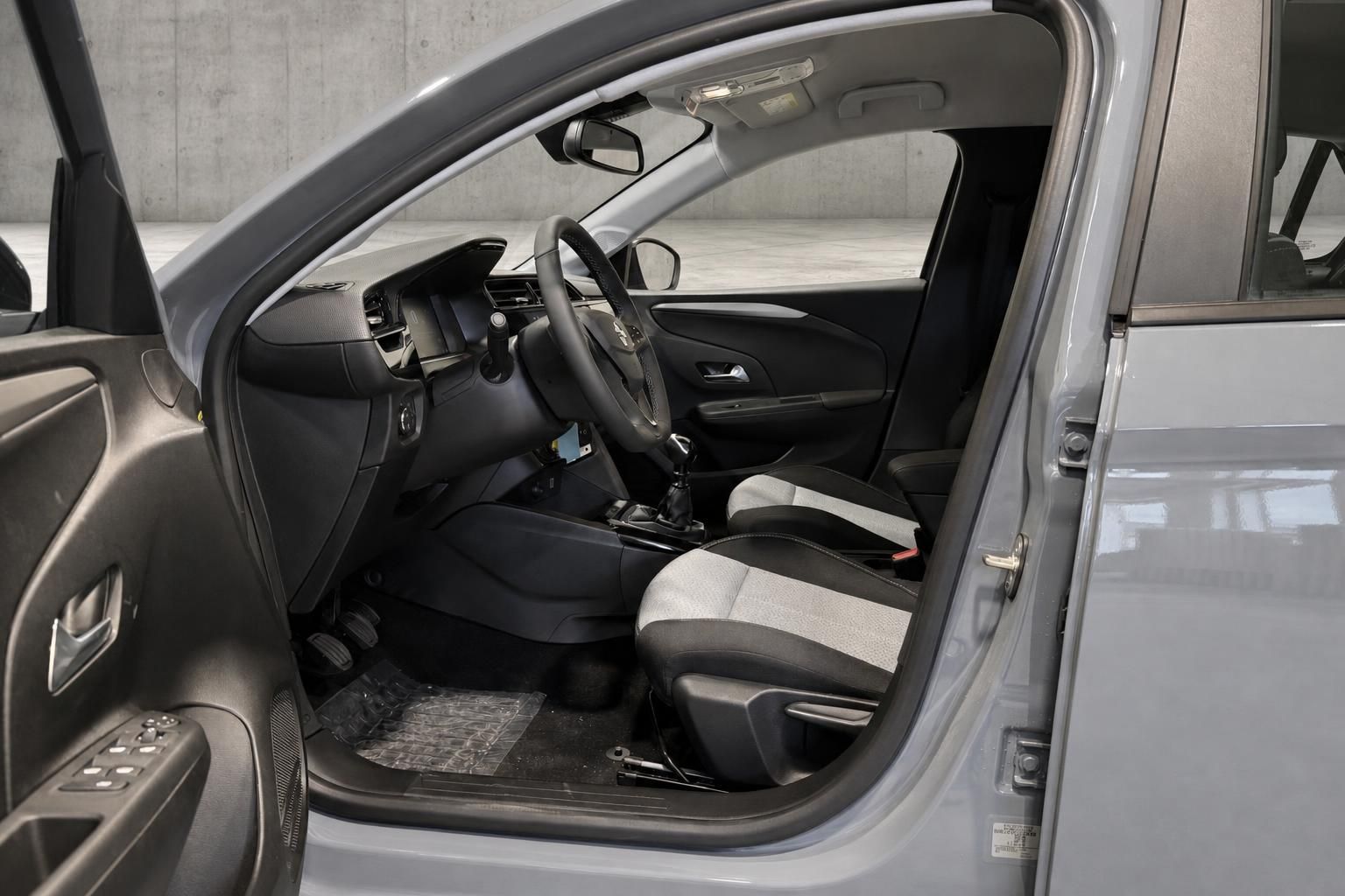 Opel Corsa Innenraum mit Blick auf Fahrersitz und Cockpit bei geoeffneter Tuer