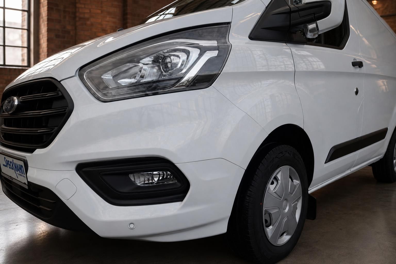 Ford Transit Custom weiss – Frontpartie mit LED-Scheinwerfern und Kühlergrill in Detailansicht