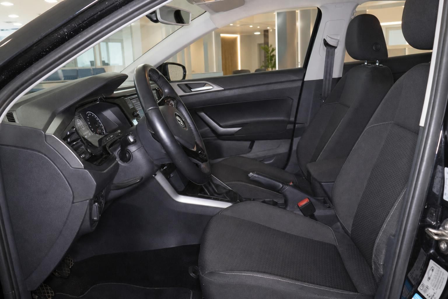 Škoda Fahrzeug Innenraum Fahrerseite mit schwarzen Stoffsitzen, Lenkrad und Mittelkonsole