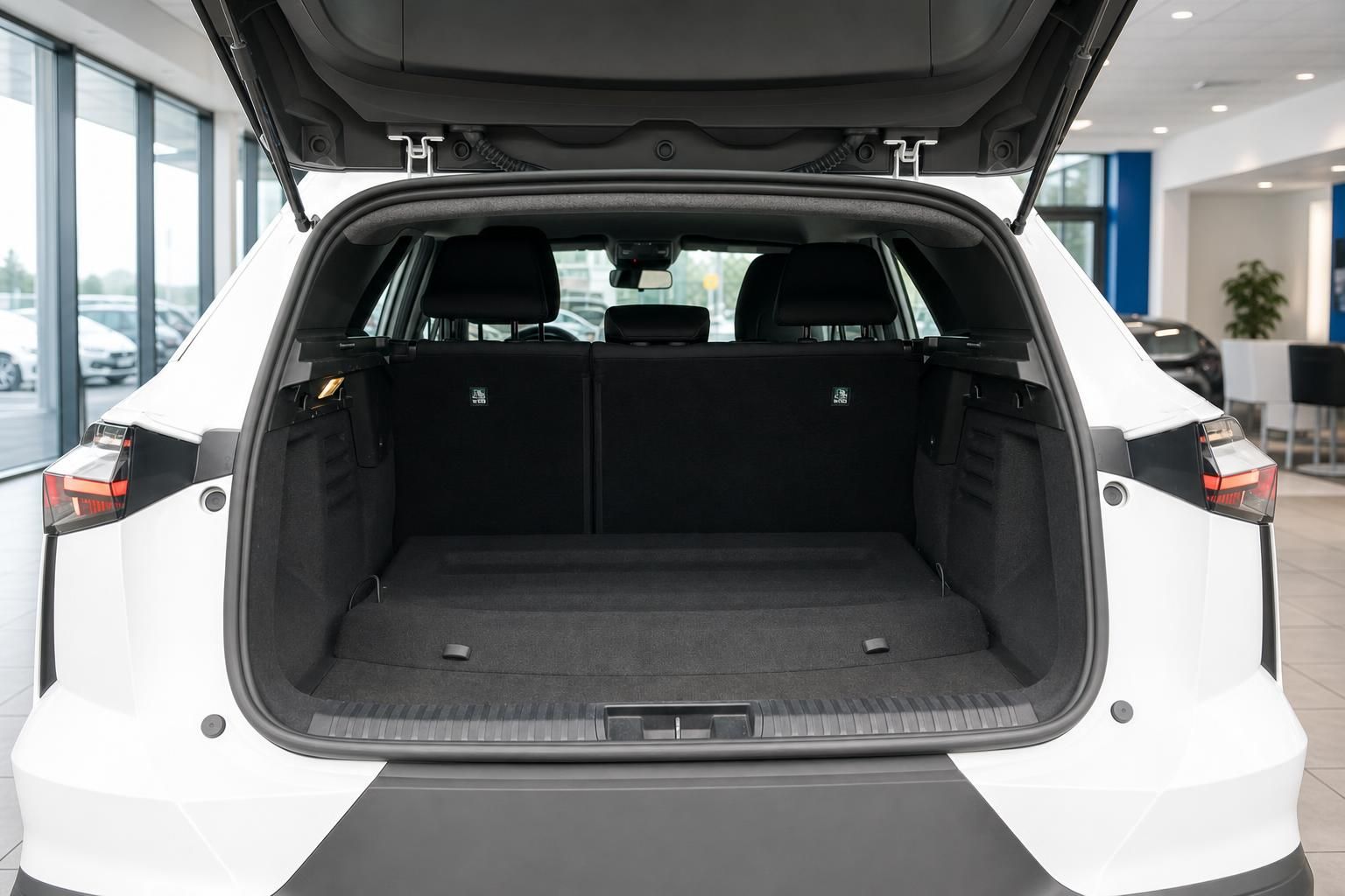 Renault Symbioz weisser SUV geoeffneter Kofferraum mit grossem Laderaum im Autohaus