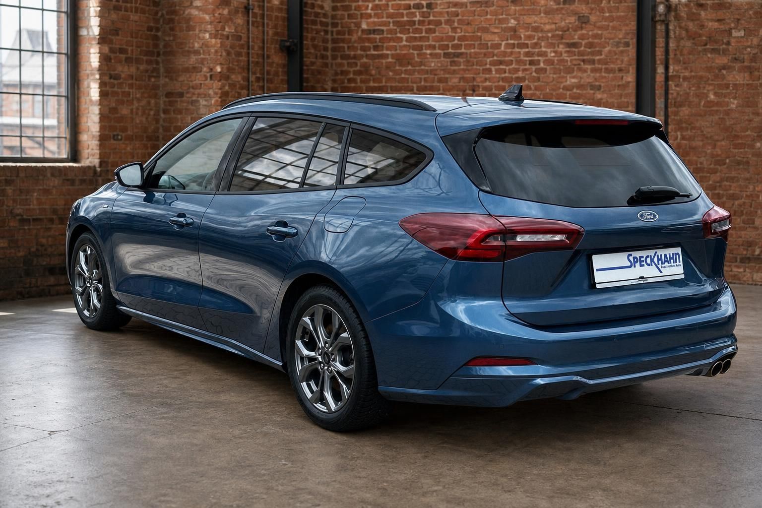 Ford Focus Turnier blau, Heck-Seitenansicht vor Backsteinwand