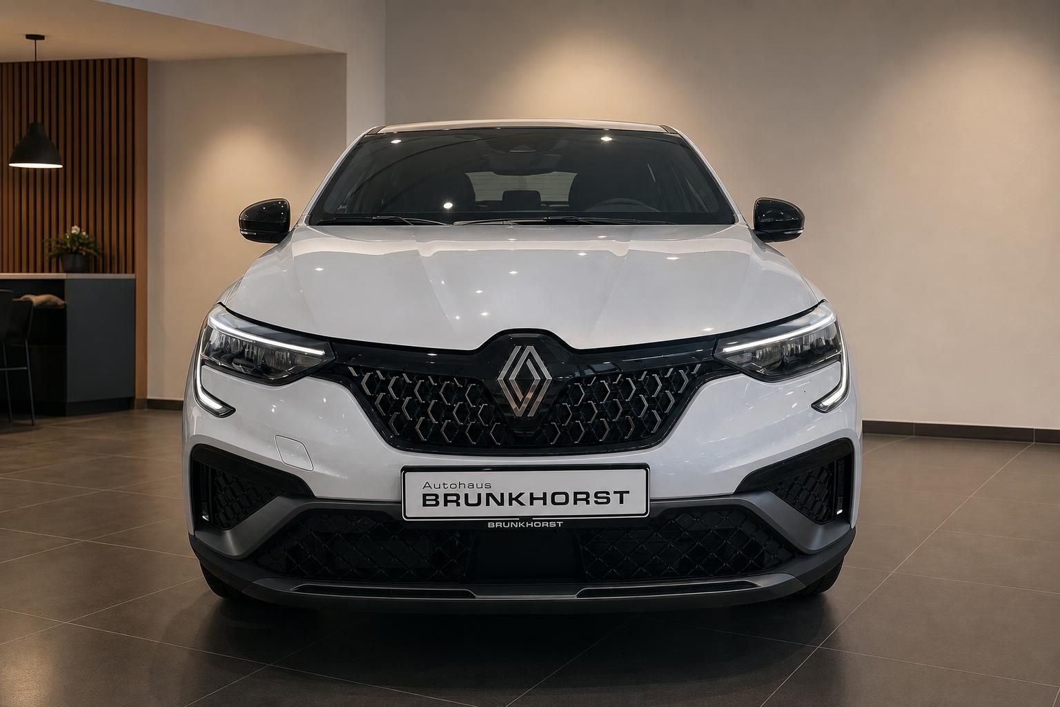 Renault Arkana Frontansicht in weiß mit schwarzem Kühlergrill im eleganten Autohaus-Showroom