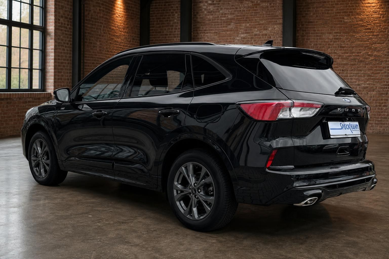 Ford Kuga schwarz Heckansicht seitlich in moderner Showroom-Halle