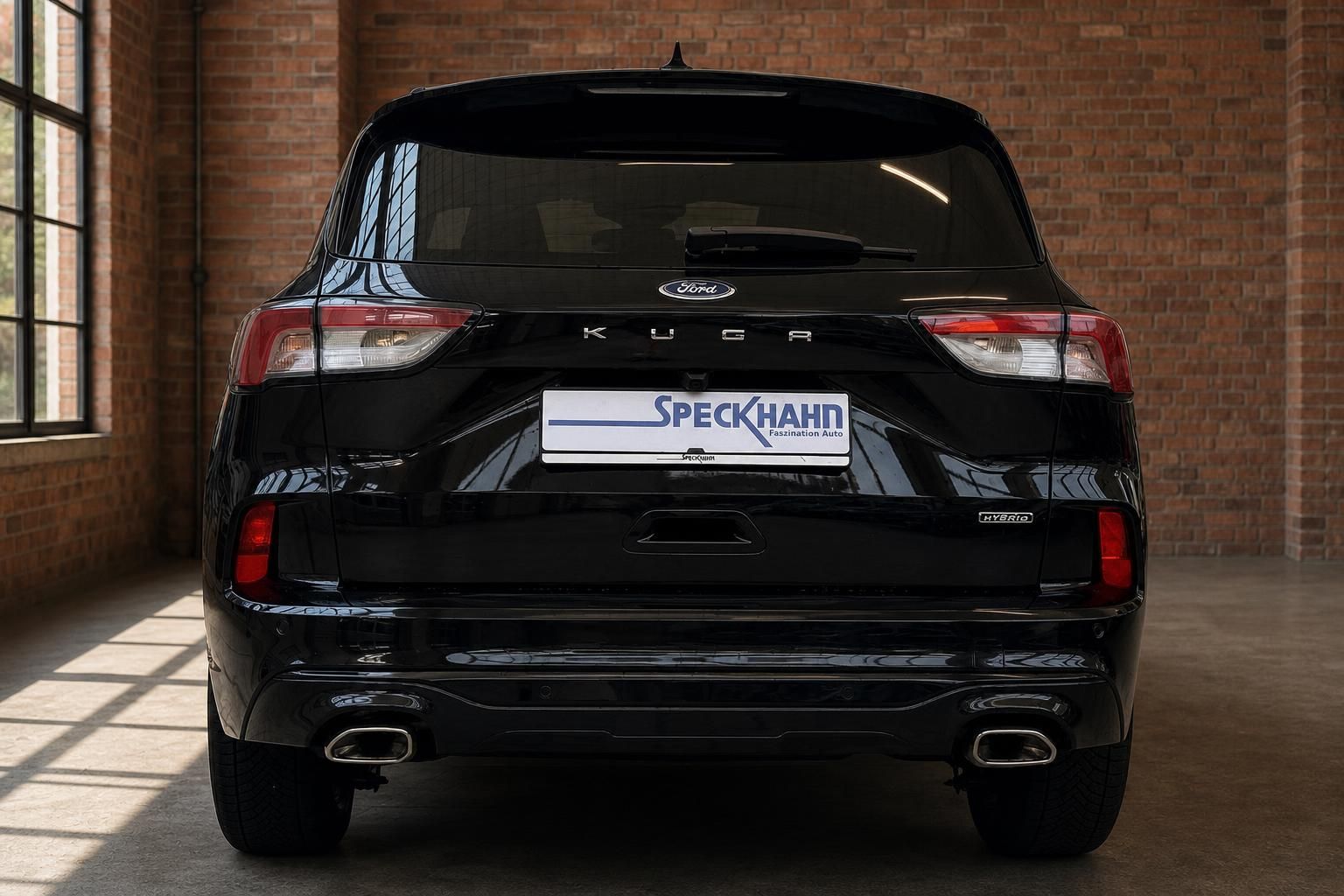 Ford Kuga Hybrid schwarz Heckansicht mit Doppelauspuff im Showroom
