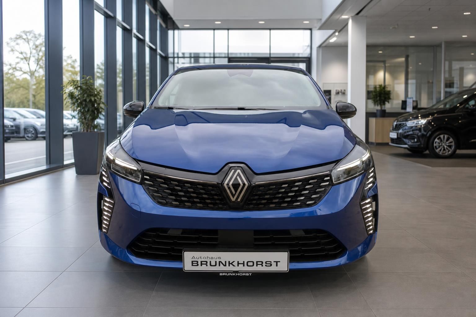 Blauer Renault Clio Frontansicht im Autohaus Showroom mit LED-Scheinwerfern und Kühlergrill