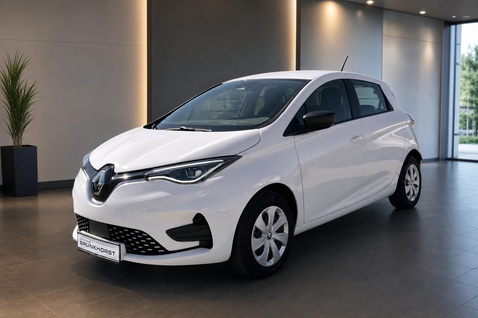 Weißer Renault ZOE Elektro-Kleinwagen im Autohaus-Showroom - Dreiviertelansicht von vorne