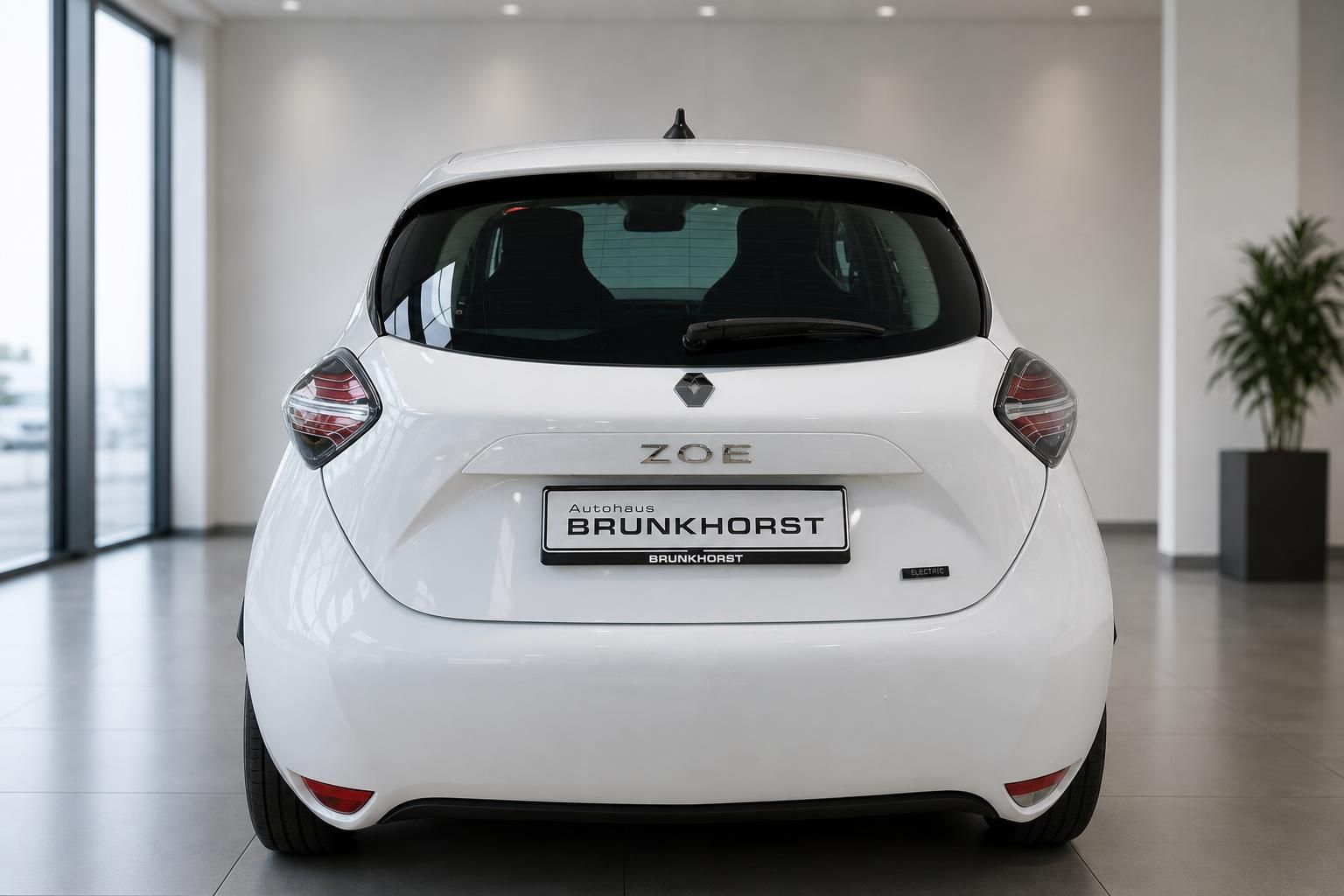 Weißer Renault ZOE Elektroauto - Heckansicht mit ZOE-Schriftzug und Händlerkennzeichen
