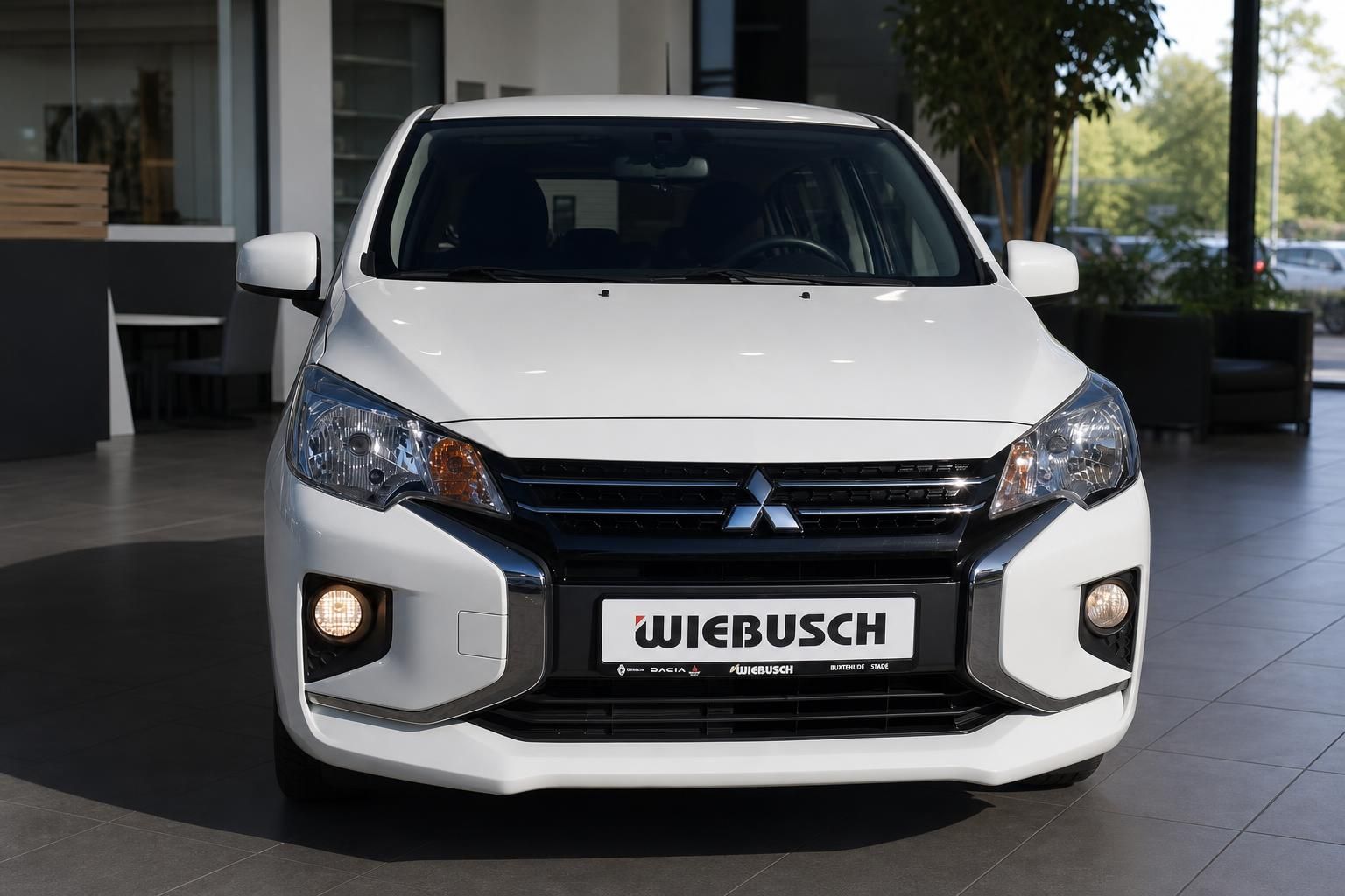 Weißer Mitsubishi Space Star Kleinwagen Frontansicht mit Mitsubishi Logo und Scheinwerfern