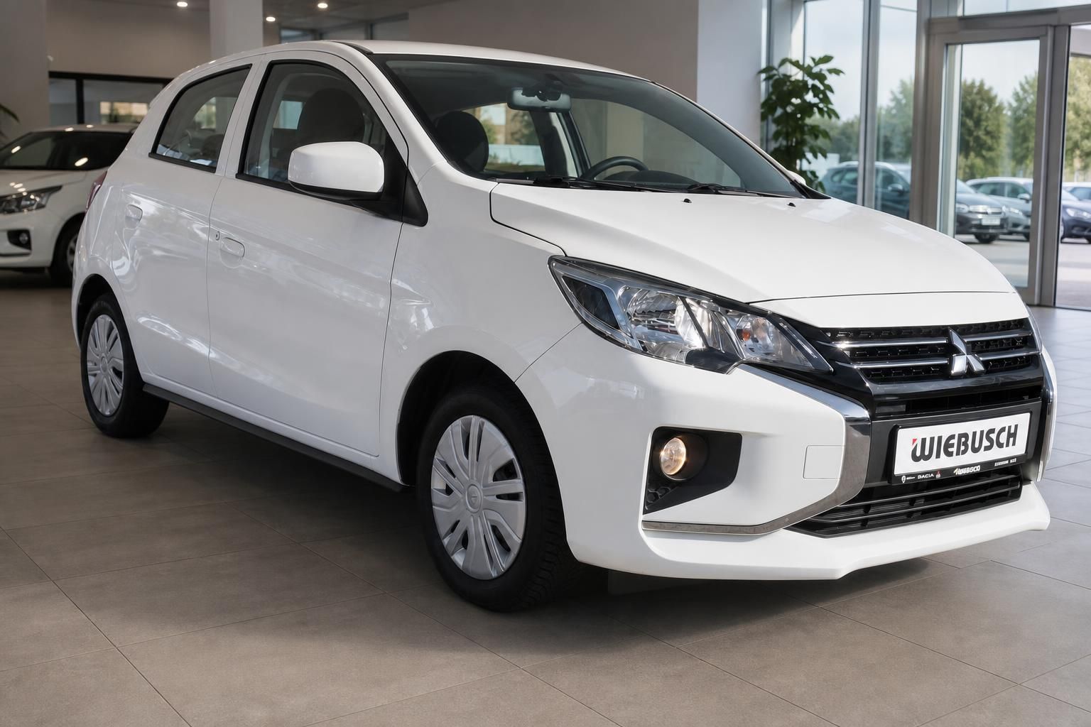 Weißer Mitsubishi Space Star Kleinwagen seitliche drei Viertel Ansicht im Autohaus