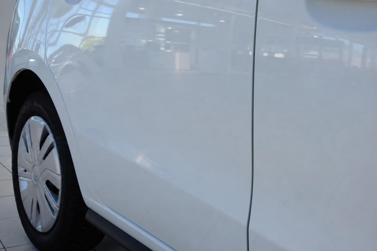Detailaufnahme weiße Fahrzeugseite mit Radkasten und Reifen eines Mitsubishi