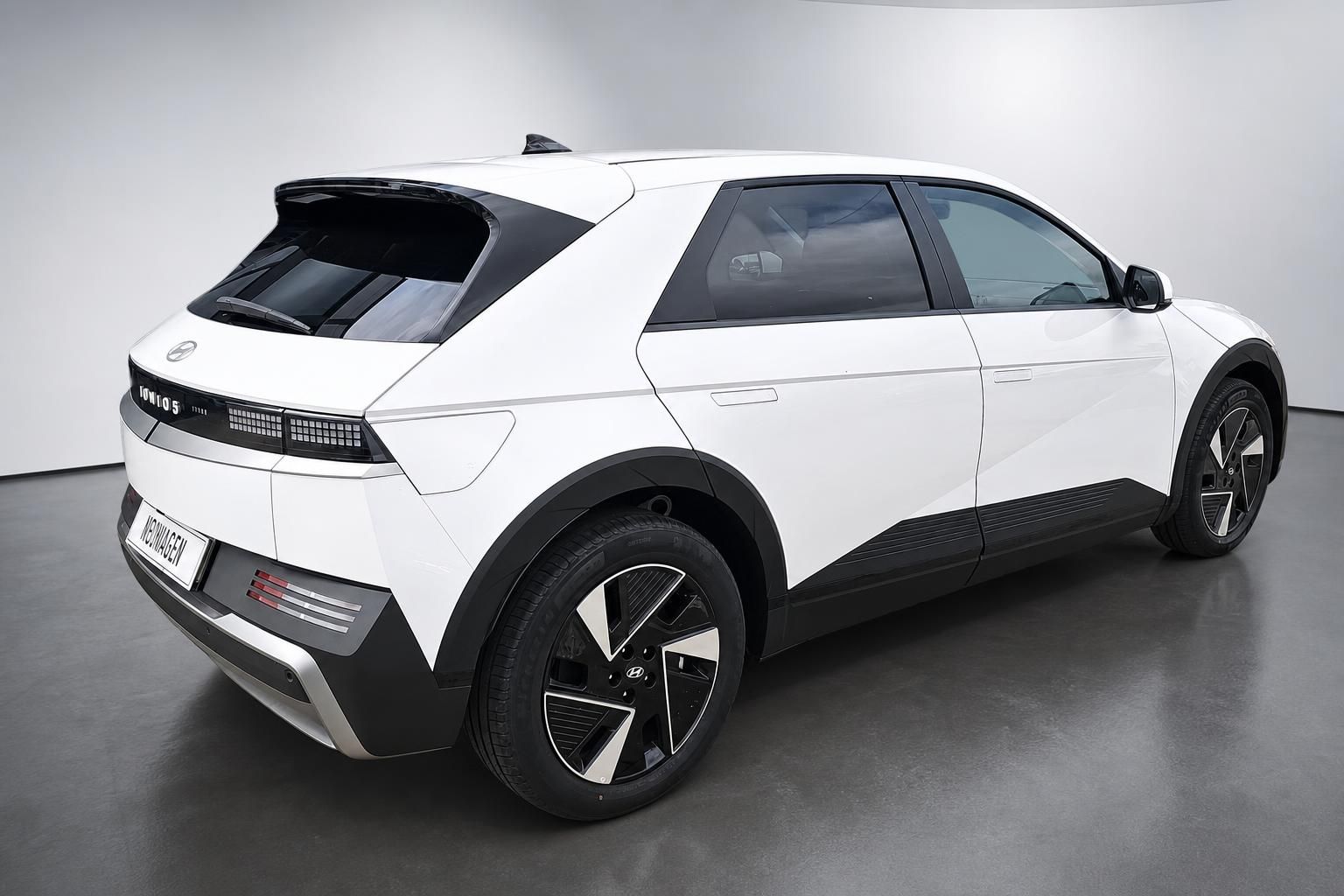 Hyundai IONIQ 5 in Weiß, Heckansicht seitlich im Studio
