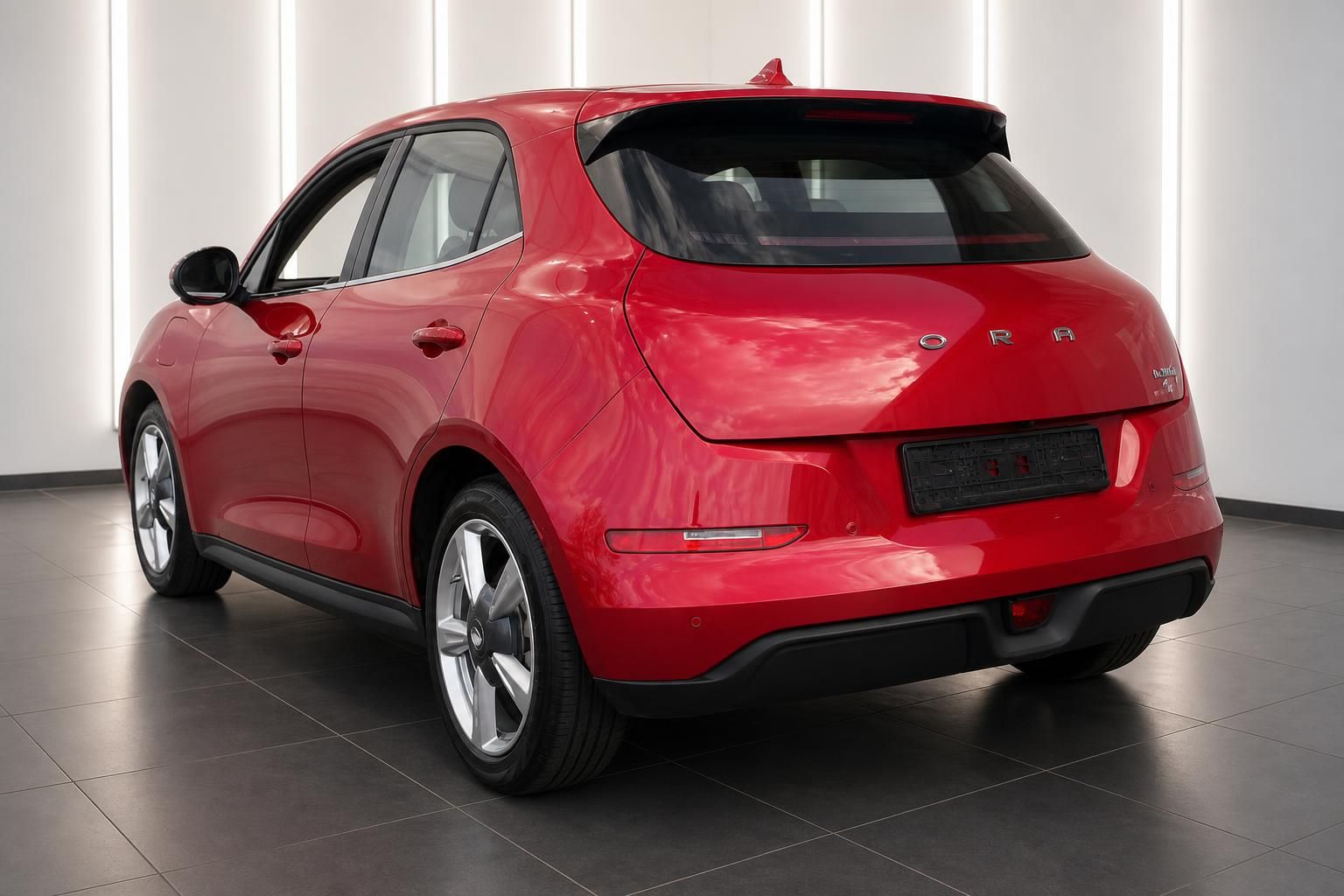 ORA Elektroauto rot Heckansicht schräg hinten rechts im Showroom mit 5-Speichen-Felgen