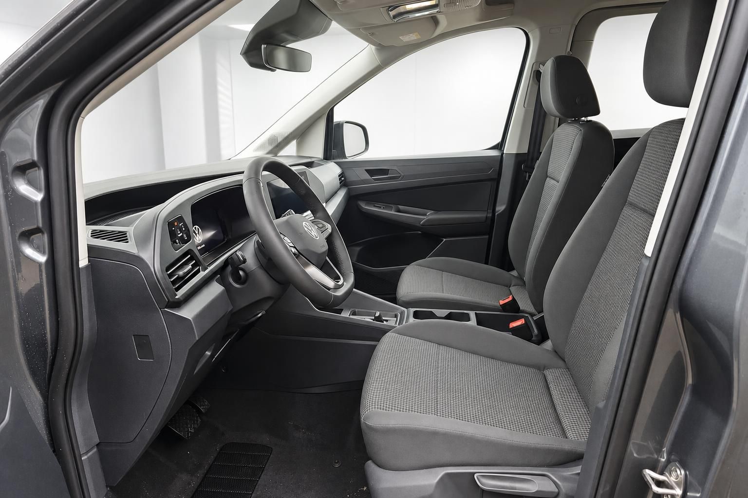 VW Caddy Fahrerraum mit Sitzen und Cockpit durch offene Tuer