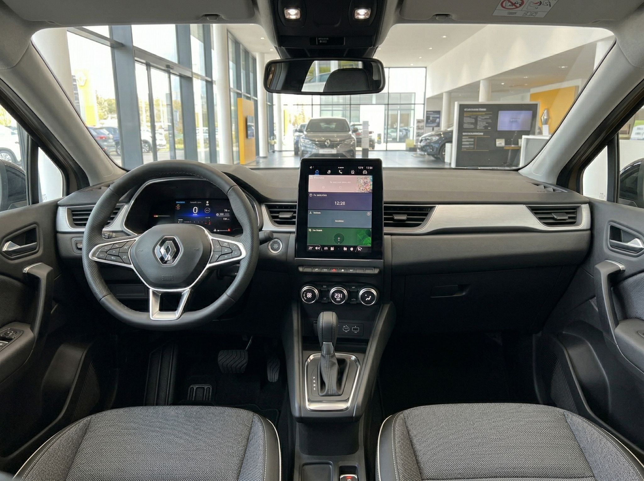 Renault Innenraum mit modernem Cockpit, Touchscreen Display und grauem Interieur im Autohaus