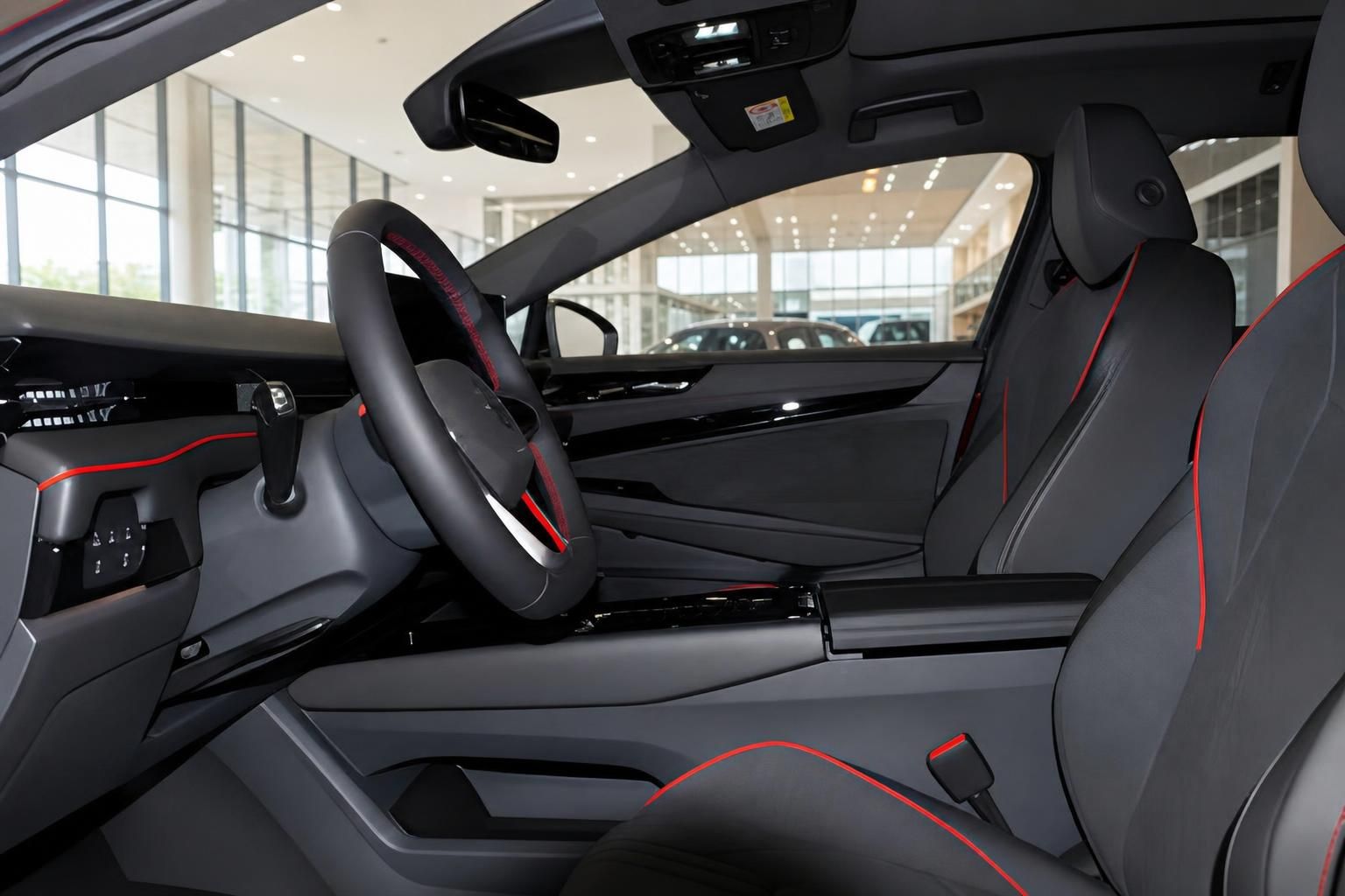 VW ID.7 Tourer GTX Innenraum Fahrerseite mit Lenkrad, Sportsitzen und roten Ziernähten im Autohaus