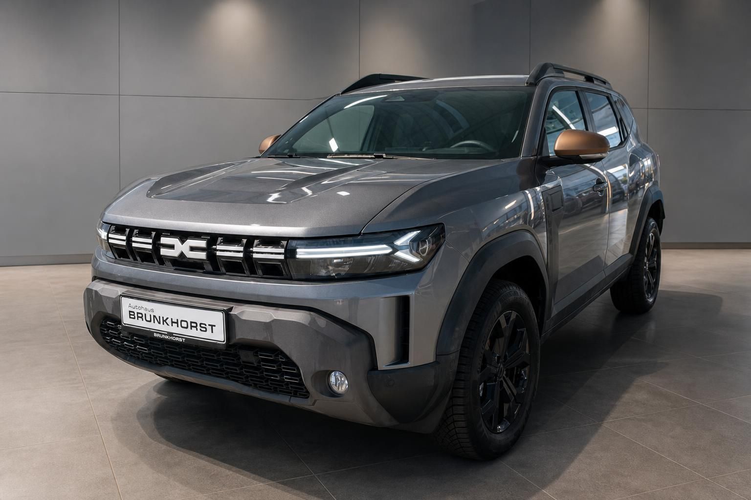 Dacia Duster SUV in Grau, Frontansicht schräg im Showroom