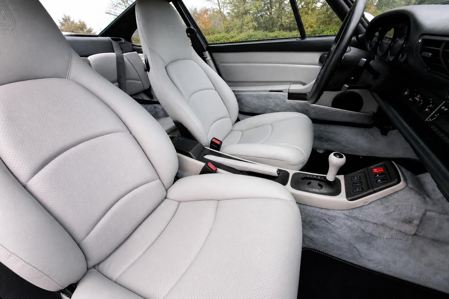 Fahrzeuginnenraum mit hellen Ledersitzen und grauem Alcantara-Interieur