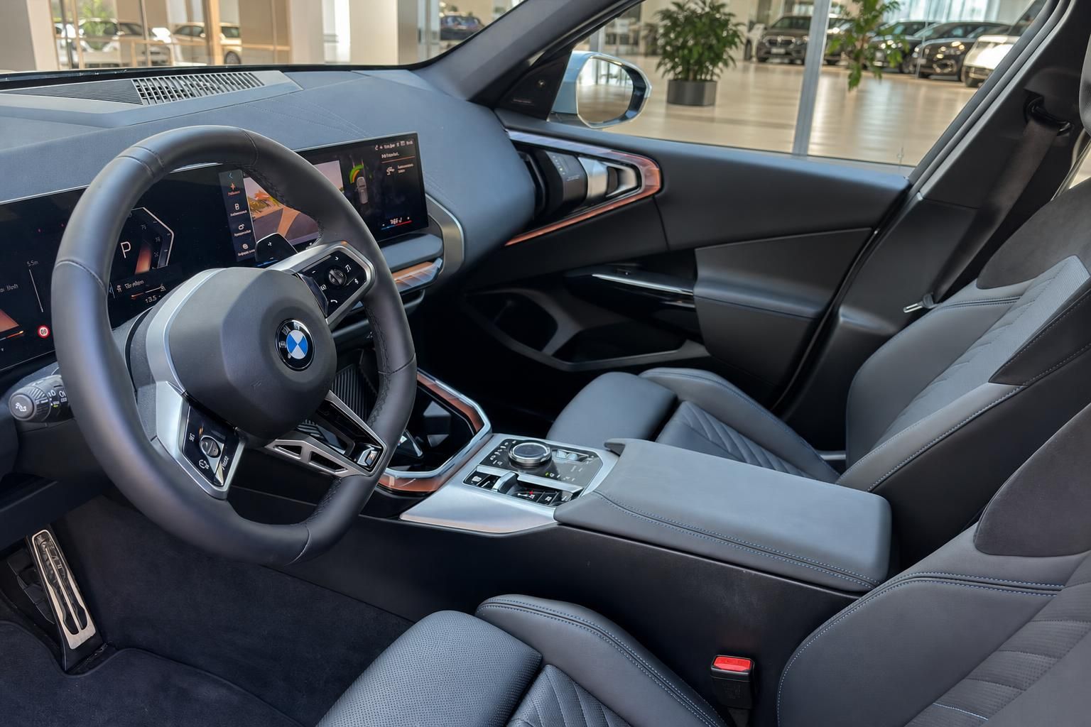 BMW Innenraum mit Lenkrad, Cockpit und schwarzen Ledersitzen im Autohaus