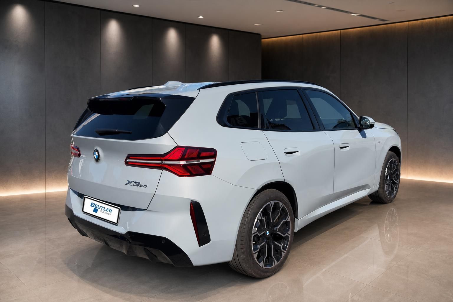 BMW X3 20d weiß, Heckansicht seitlich in moderner Ausstellungshalle