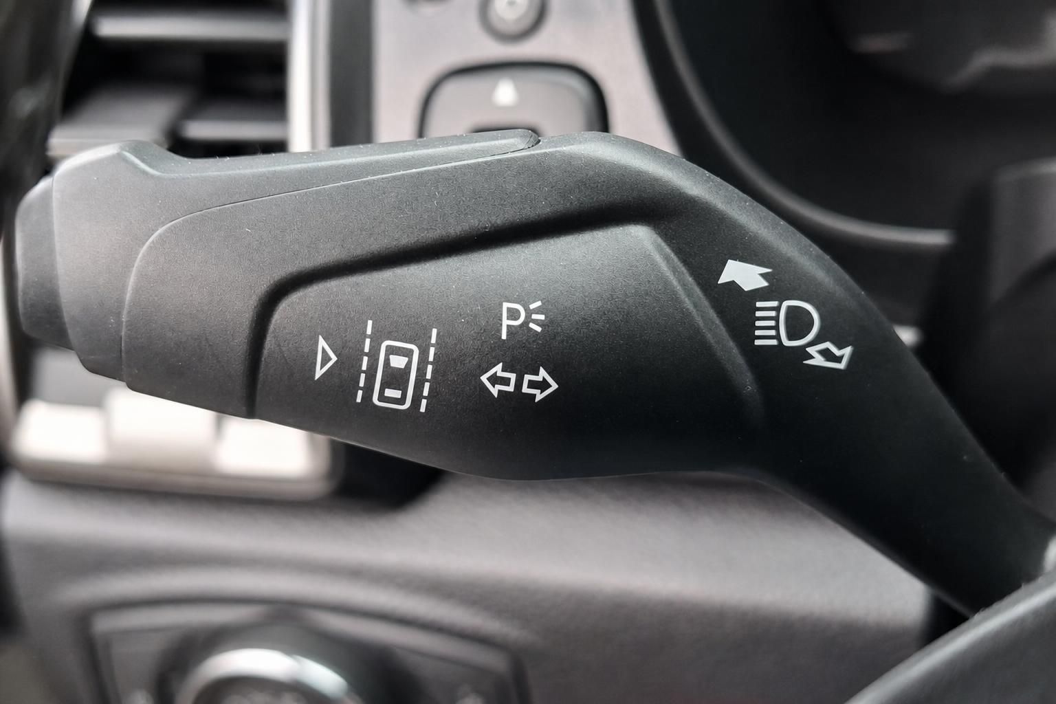 Fahrzeug-Blinkerhebel mit Parksensor-Symbolen und Scheinwerfer-Bedienung am Lenkrad