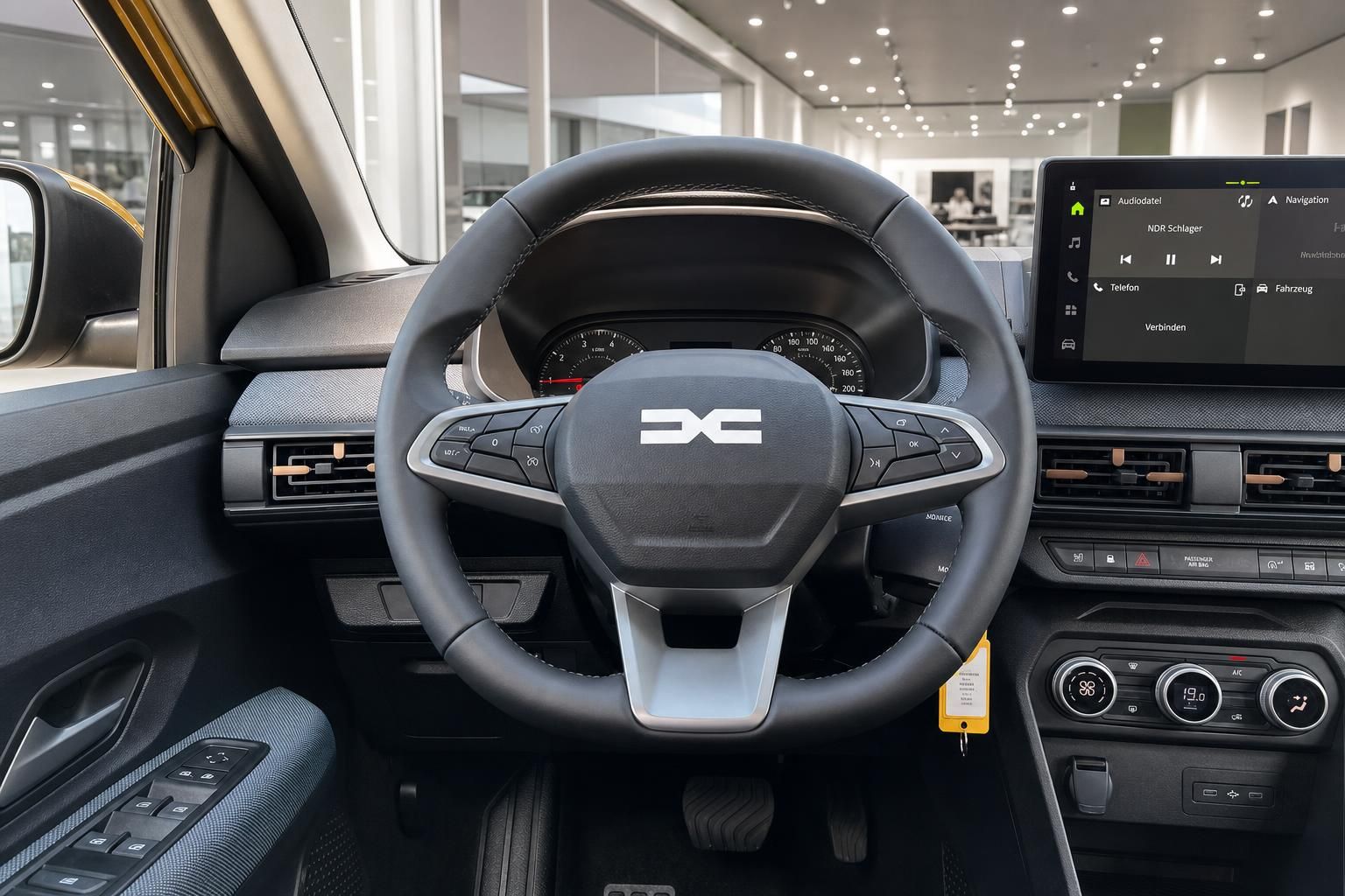 Cockpit mit Lenkrad, Tacho und Touchscreen-Infotainmentsystem im Innenraum