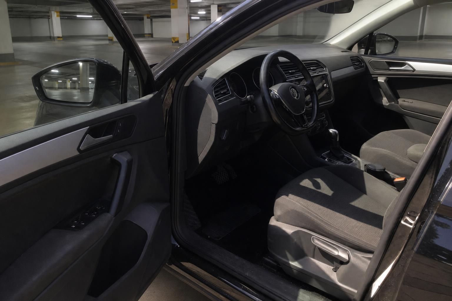 VW Tiguan Innenraum mit geoeffneter Fahrertuer und Cockpit