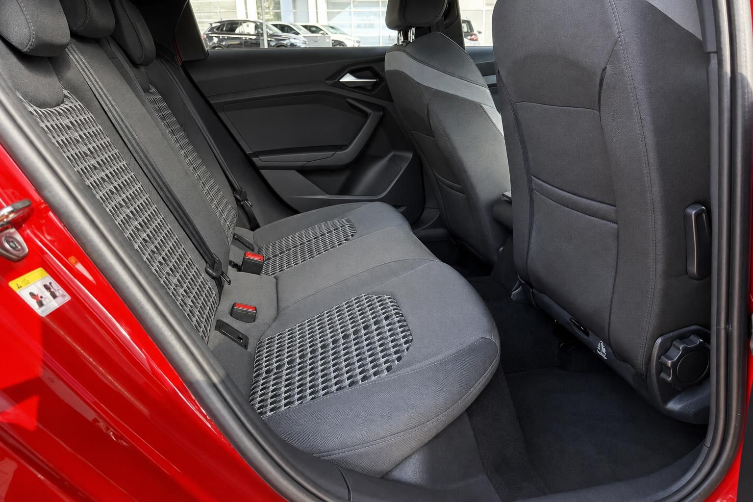 Audi A1 Rücksitzbank mit grauem Stoff-Alcantara-Bezug und Sicherheitsgurten, rote Türverkleidung