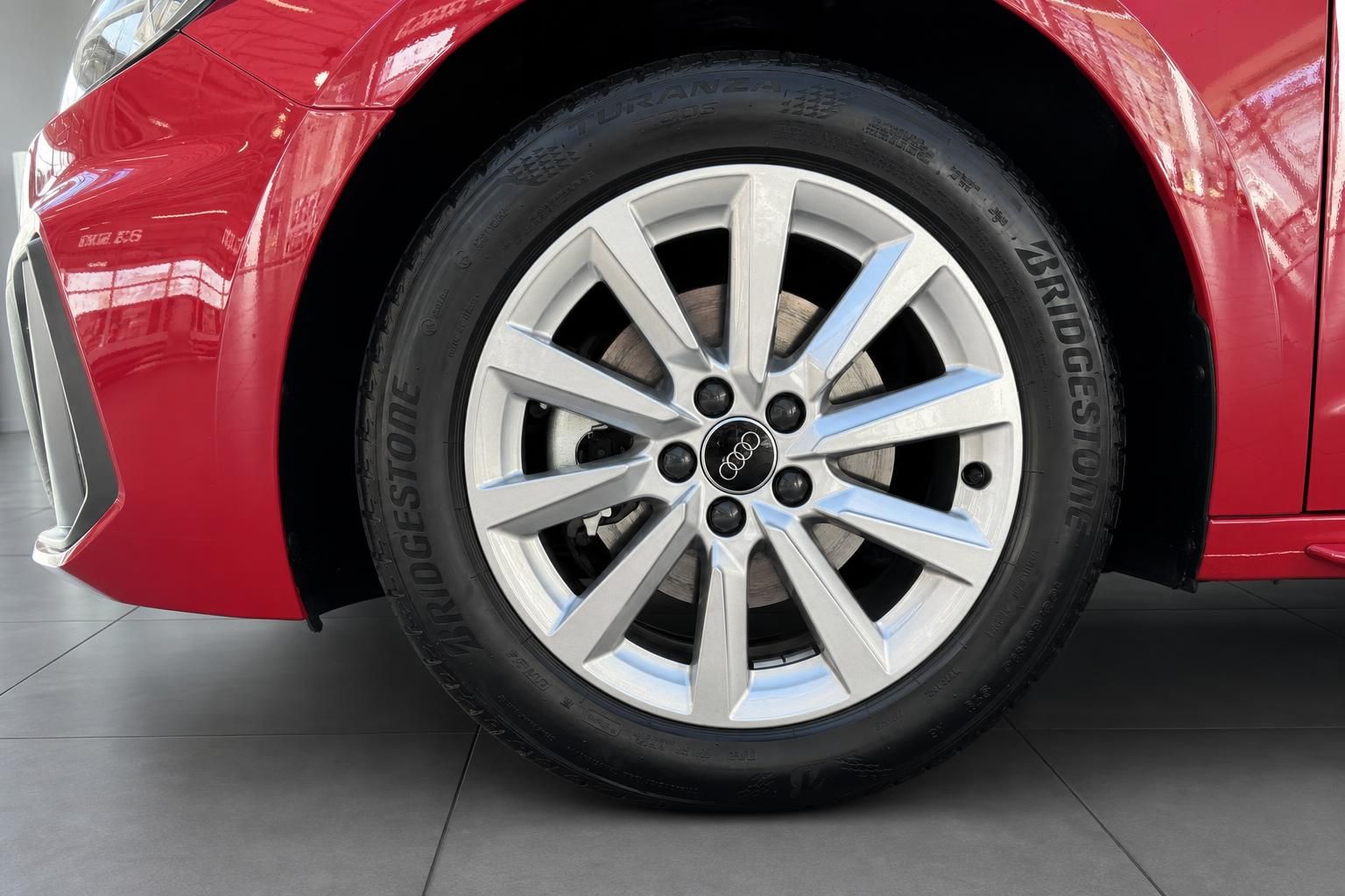 Audi A1 Alufelge Detailansicht mit Bridgestone Reifen in roter Karosserie im Autohaus