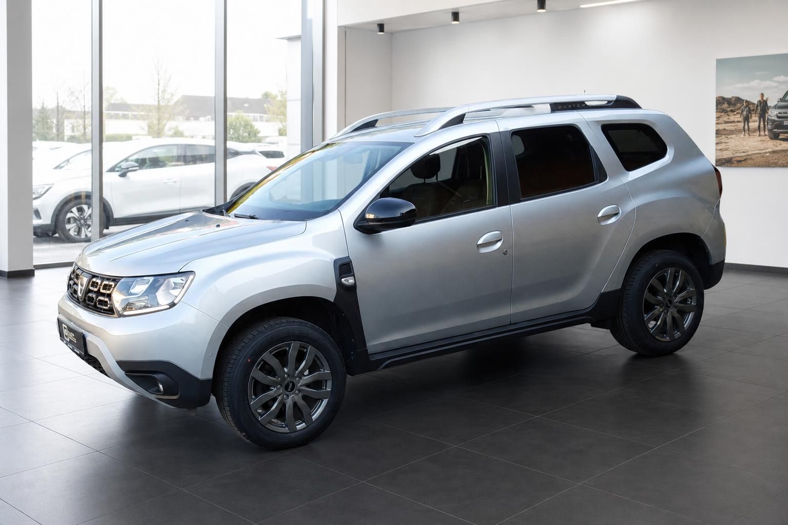 Dacia Duster silber Schrägansicht vorne links im Autohaus Showroom