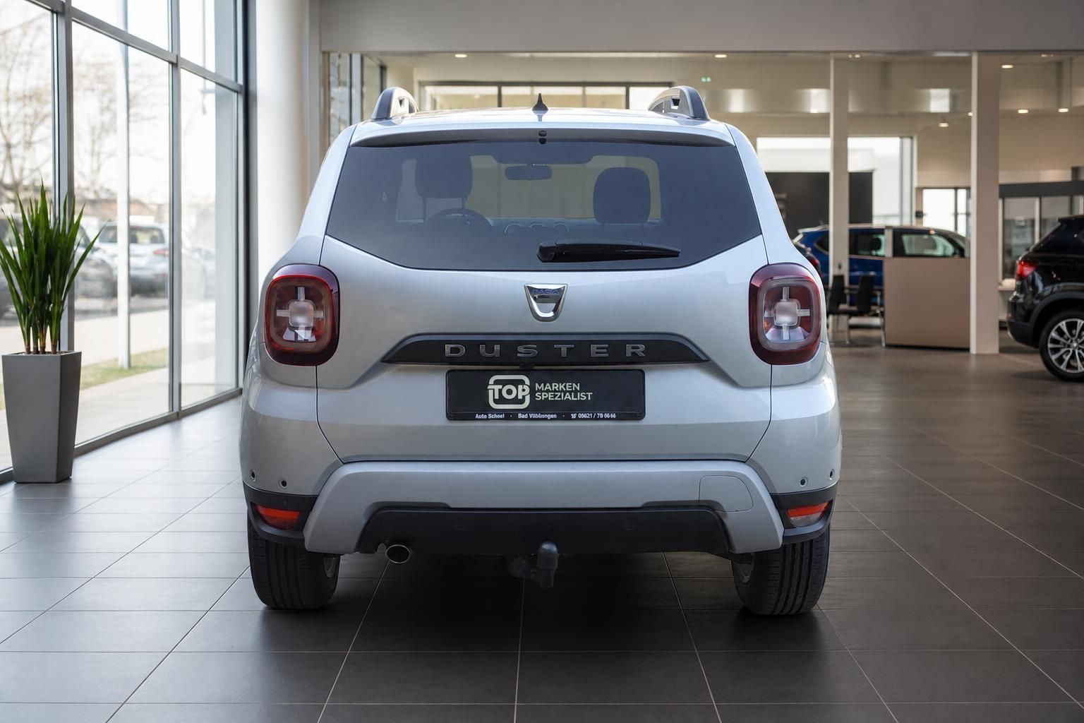 Dacia Duster silber Heckansicht mit Anhängerkupplung im Autohaus