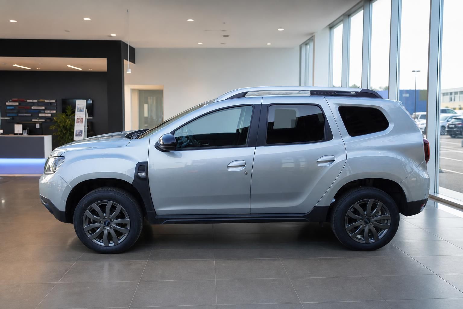 Dacia Duster silber Seitenansicht links im Autohaus Showroom