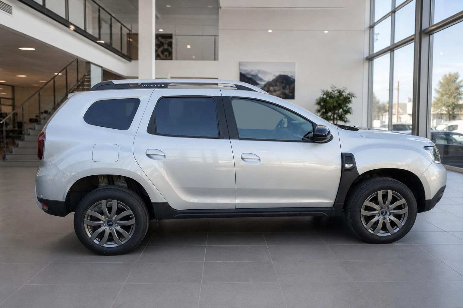 Dacia Duster silber Seitenansicht im Autohaus – SUV mit Dachreling und Leichtmetallfelgen